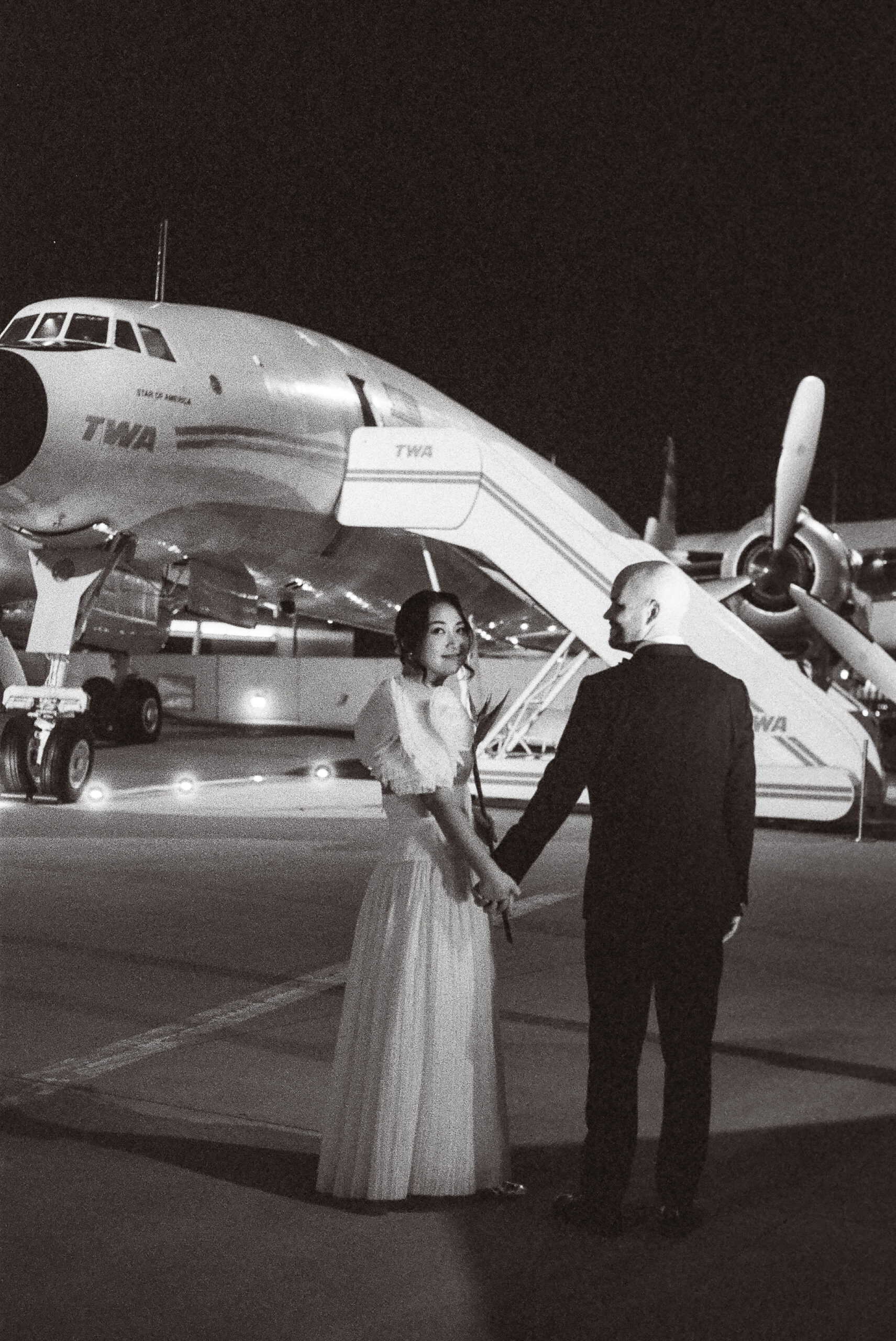 couple at the twa hotel on the tarmac shot on black and white film by parkers pictures